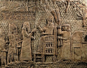 Sennacherib on his throne in camp. Detail of the Assyrian conquest of the Jewish fortified town of Lachish (battle 701 BCE). Part of a relief from the palace of Sennacherib at Niniveh, Mesopotamia (Iraq)